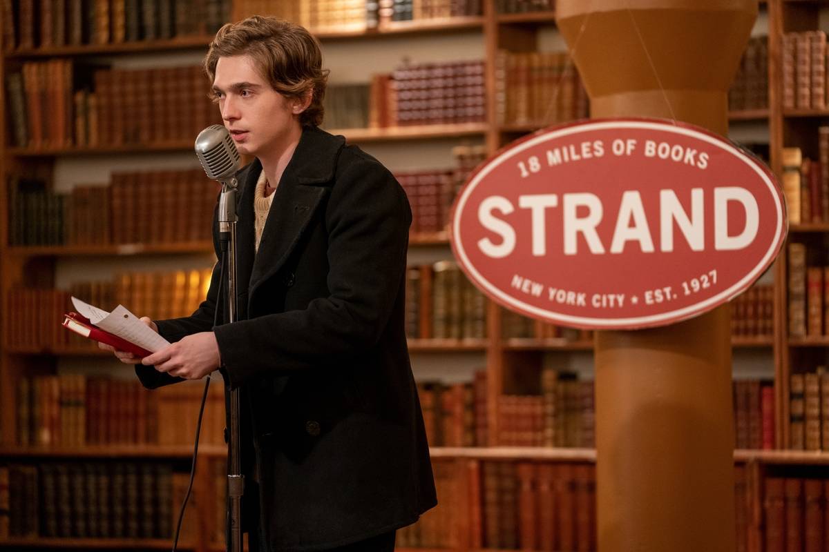 man reading at a microphone in a bookstore in dash & lily