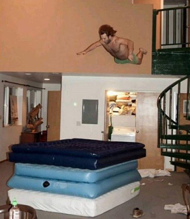 bonehead move person jumping from balcony onto pile of inflatable mattresses
