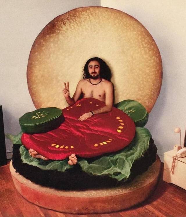 man gives peace sign in burger bed
