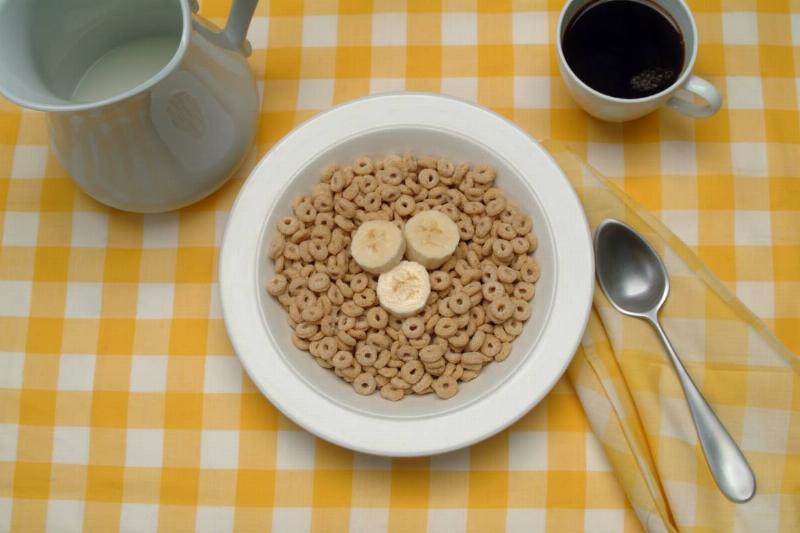 A bowl of cereal with banana slices is seen.