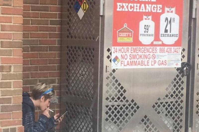 girl smoking in front of propane girl smoking in front of propane containers