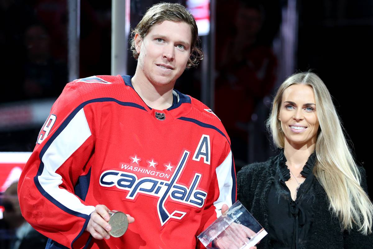 Liza stands by Nicklas as he accepts an award.