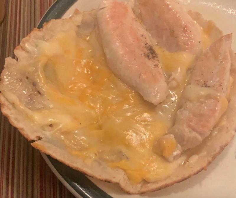 chicken and cheese a tortilla with melted cheese and sort of cooked chicken on it