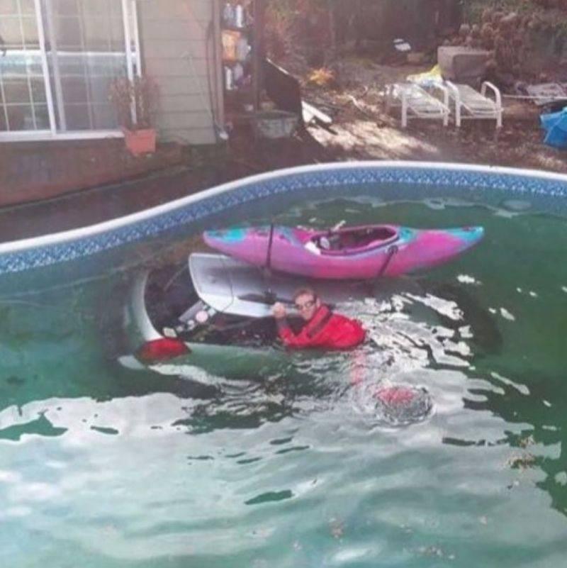 pool canoe a guy in the pool holding onto his car that sunk with a boat on top