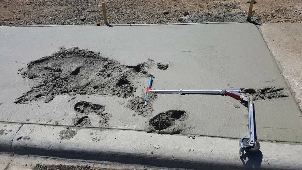 scooter stuck in drying cement with imprint of person who fell into it