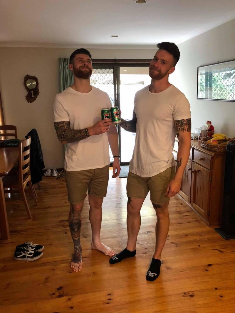 two brothers in same outfit two brothers in same outfit cheering beers