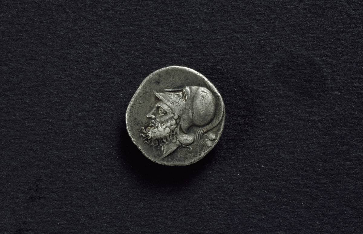 A Roman coin from 320 BC is laid on a black cloth.