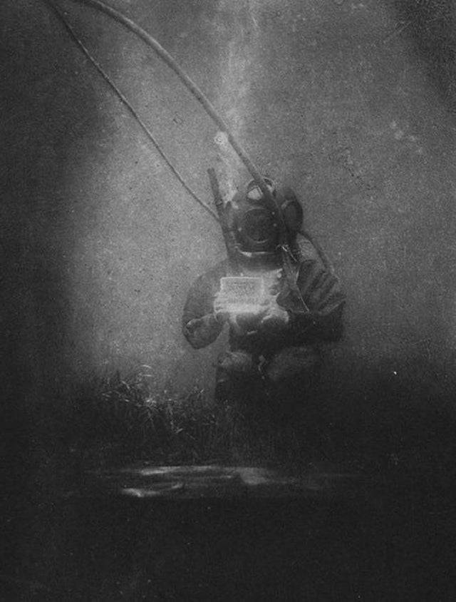 A diver is underwater in the oldest underwater photograph.