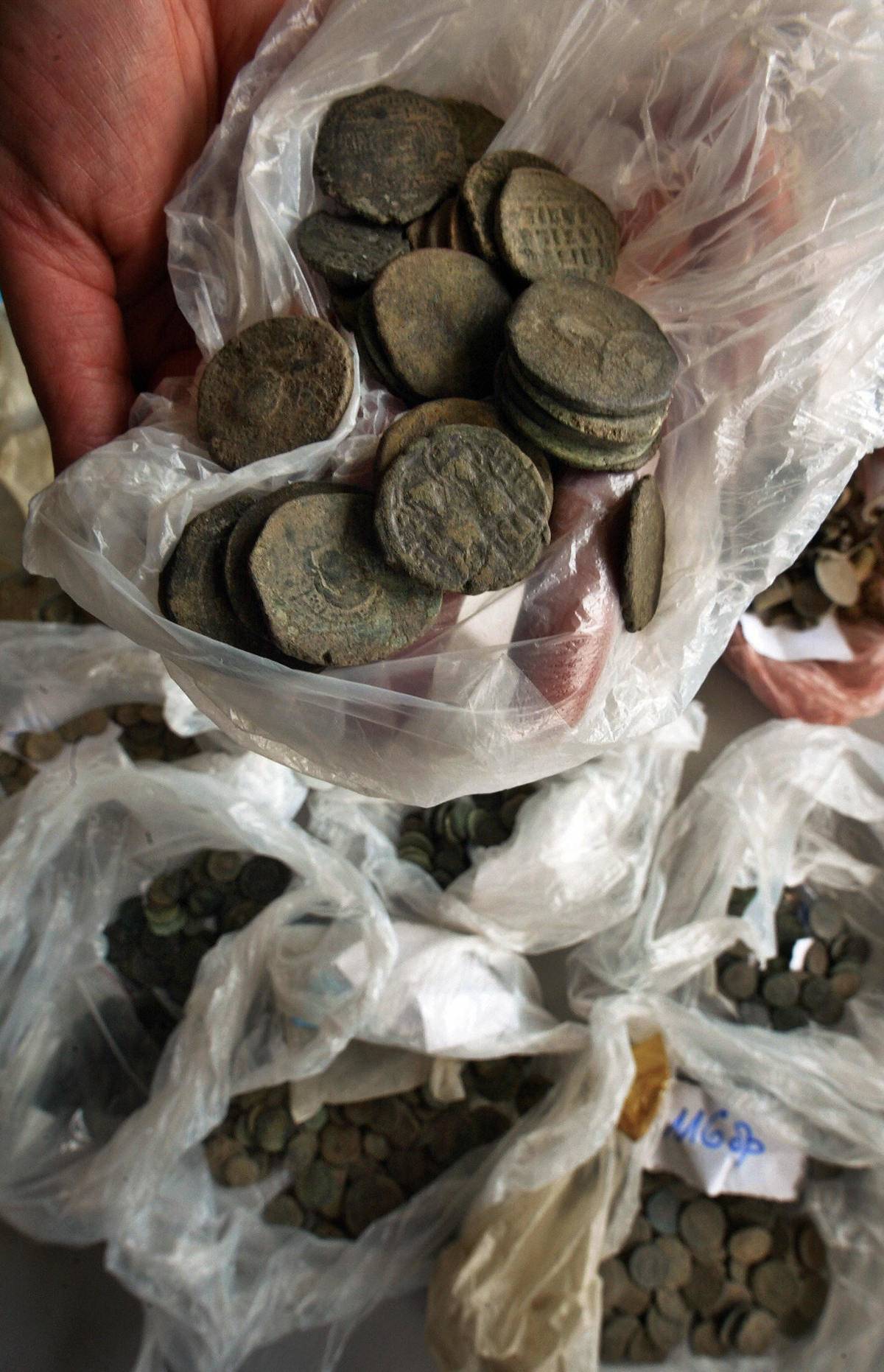 An archaeologist reveals plastic bags filled with Roman coins.