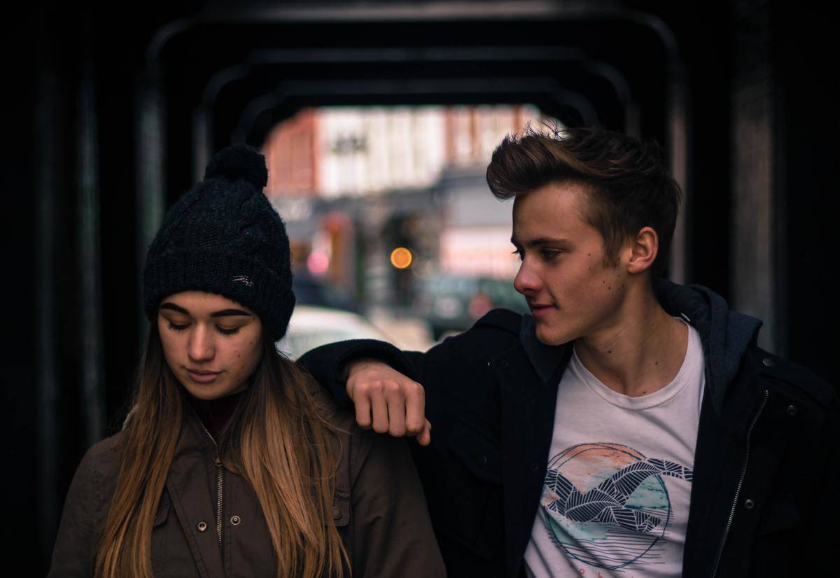 a couple walking together under an underpass 