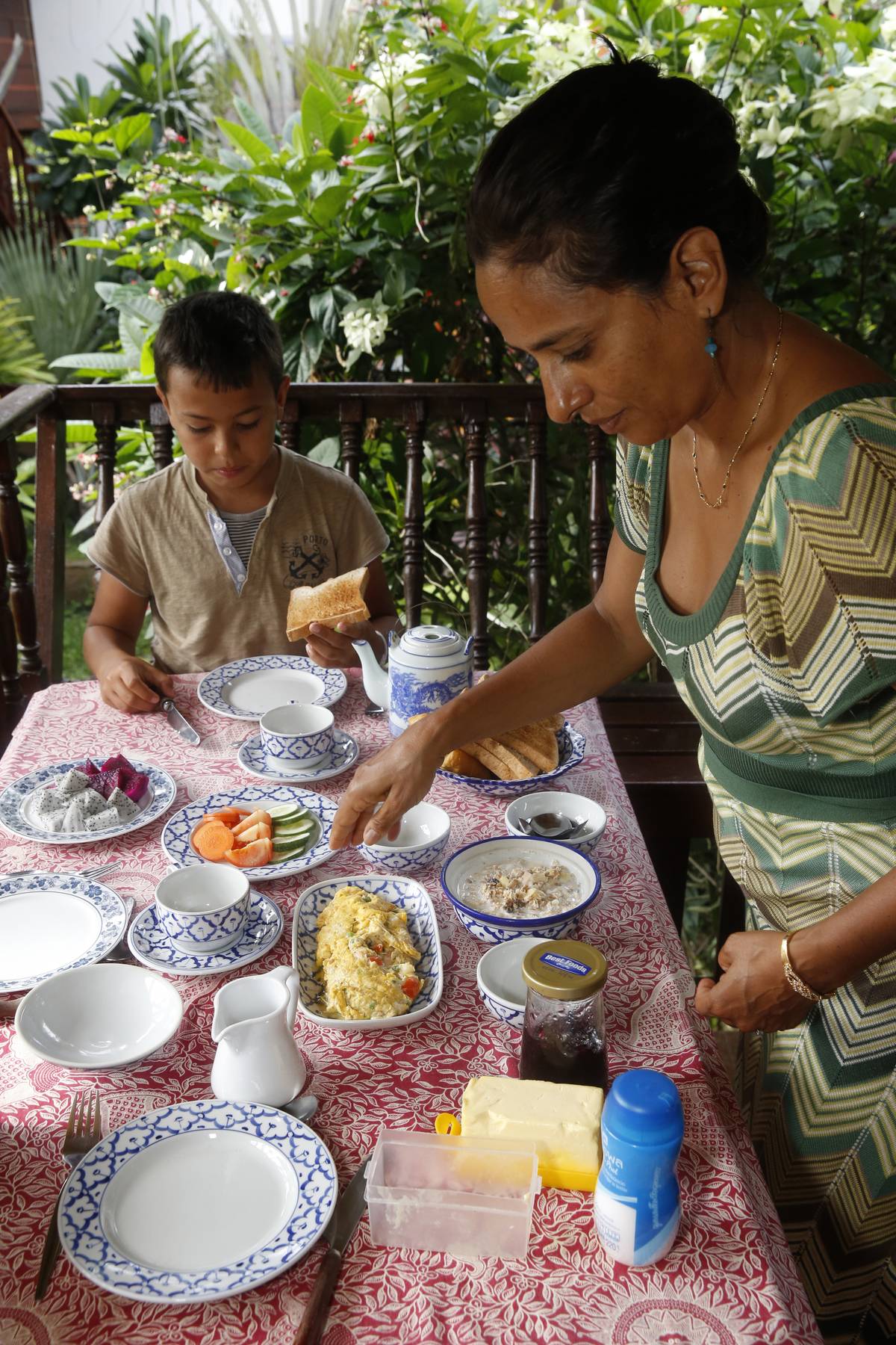 Mother and son having breakfast on holiday in Thailand.