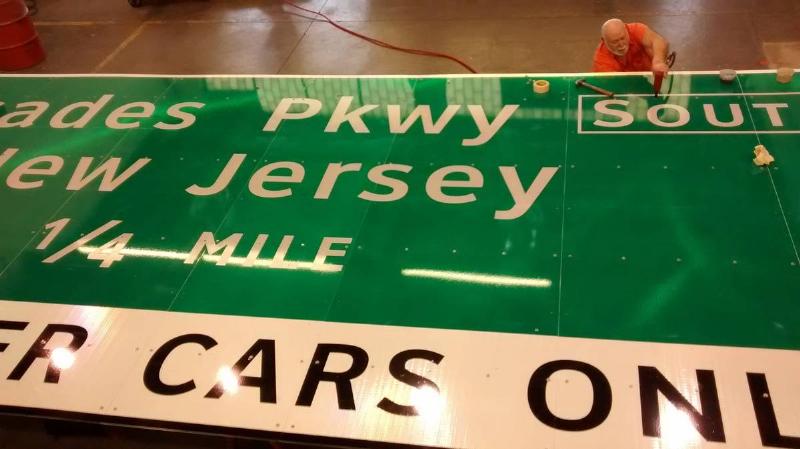 a guy fixing a road sign 
