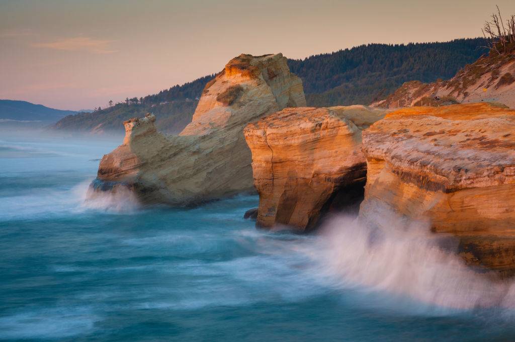 Waves crashing on cliffs at sunset in Tillamook Coast, Oregon