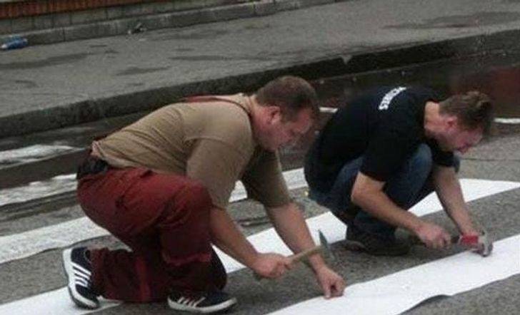 man nailing paint to road