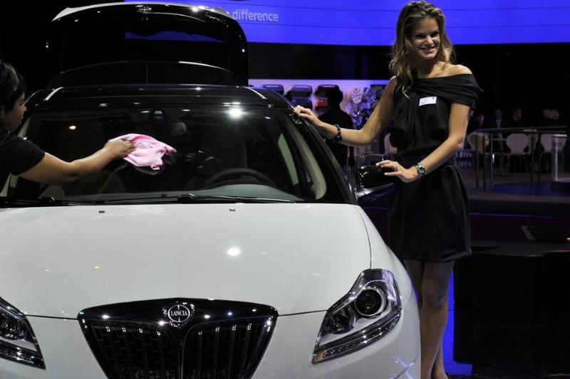 A woman clears a Lancia car during the p A woman clears a Lancia car during the p