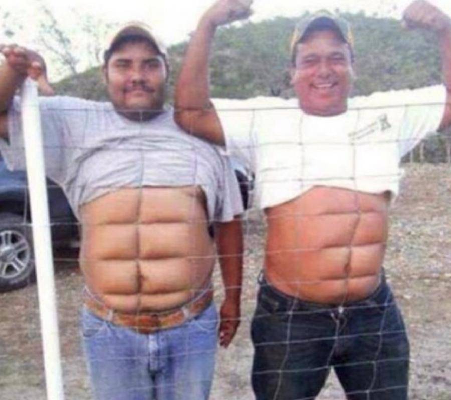 men pressing stomachs against fence to create eight pack