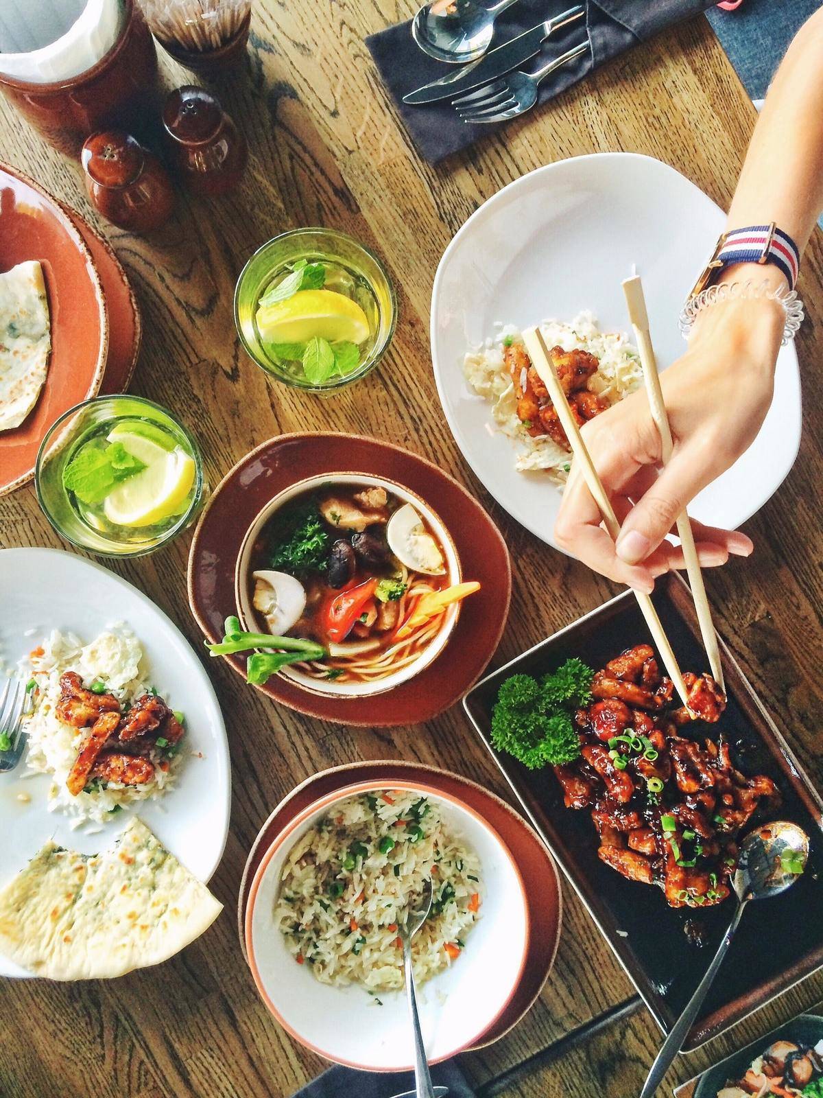 Asian cuisine on table, hand with chopsticks