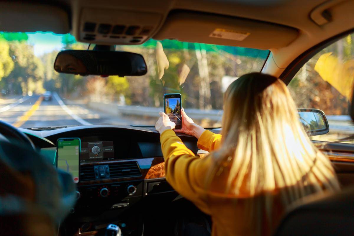 Couple in car, blonde girl taking pictures