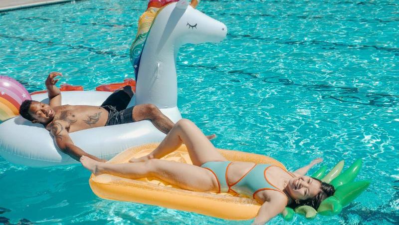 Couple smiling on pool floaties