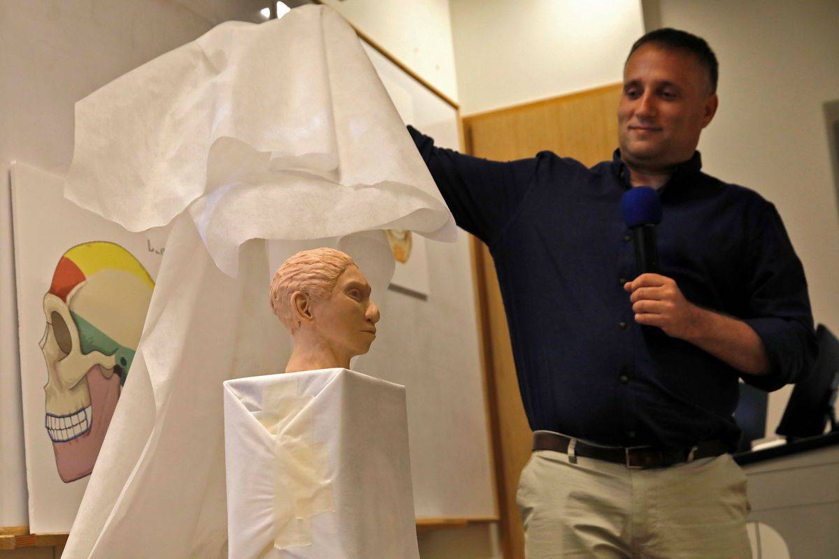 A professor reveals a 3D model of the head of an ancient human, the Denisovan.