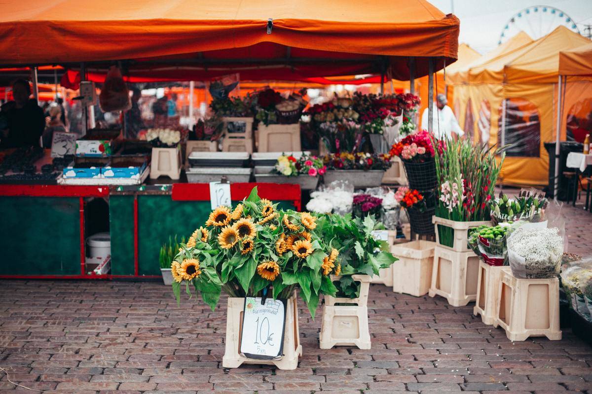 Farmers' market with sunflowers on display, orange tents