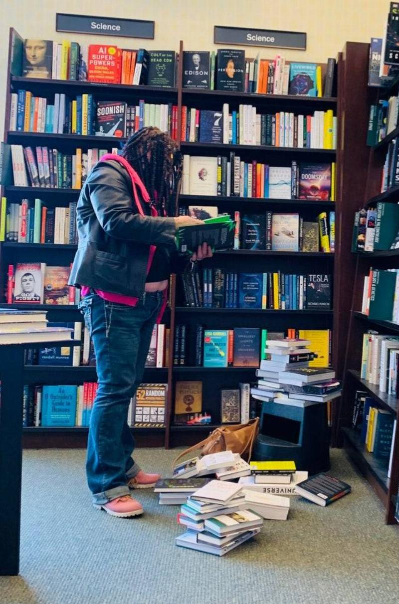 woman taking books off shelf