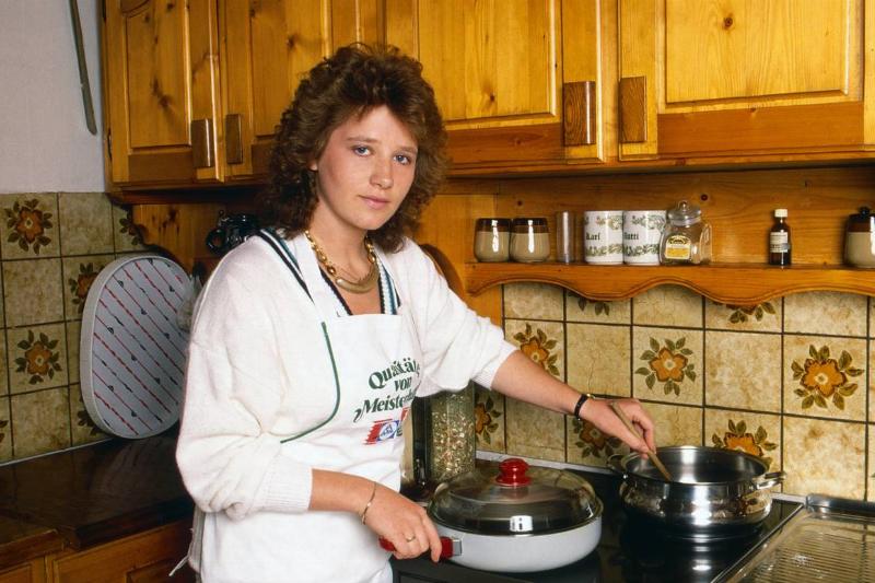 A woman cooks at her stove, 1989.