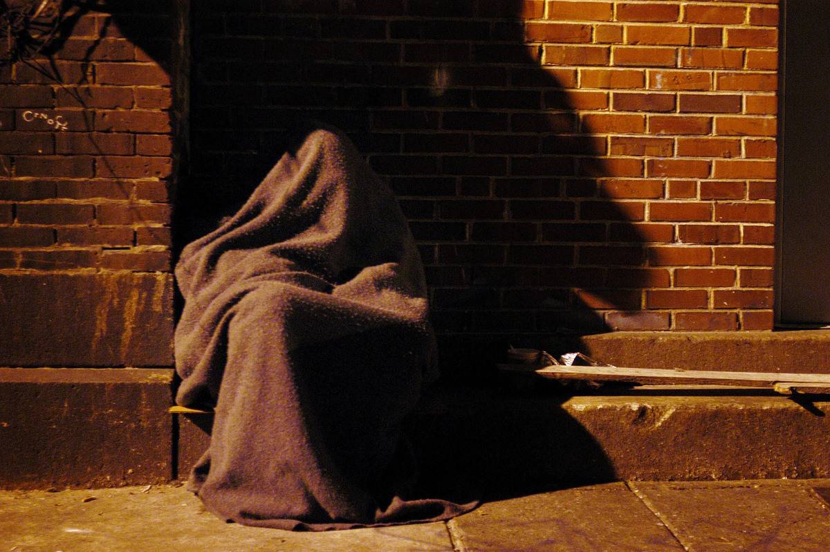 homeless blanket In Pennsylvania, a homeless man sits on the curb covered in a blanket to keep warm.