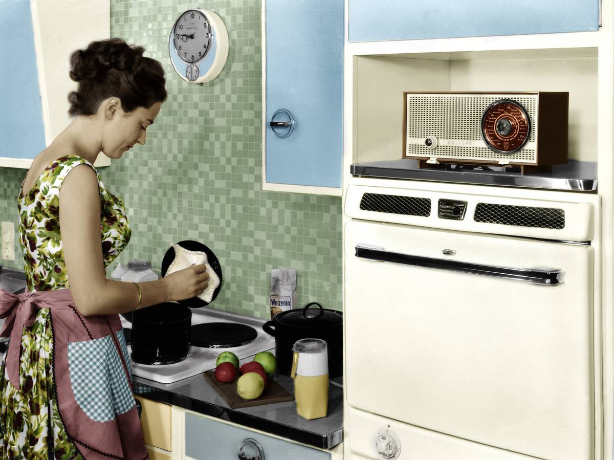 A woman cleans her kitchen appliances, 1959.