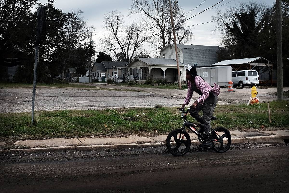 mississippi A man rides past a dilapidated house on a dirt road in Mississippi.