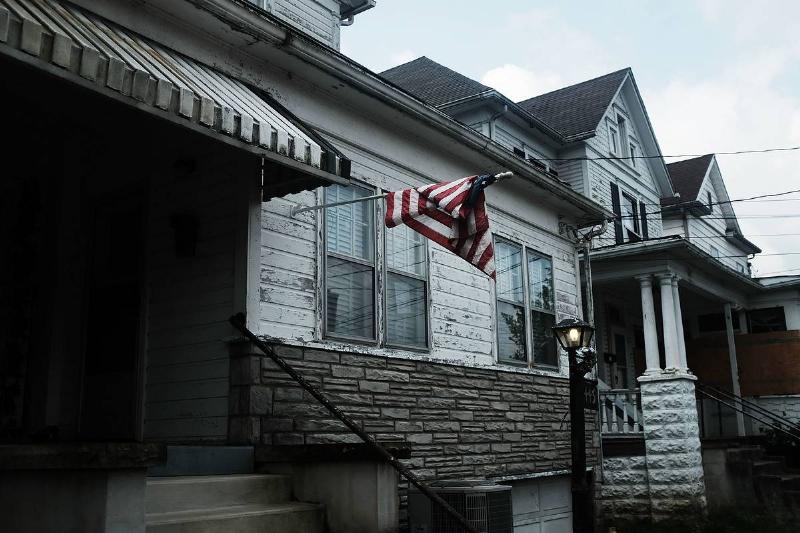 tangled flag An American flag is tangled above two impoverished homes in West Virginia.