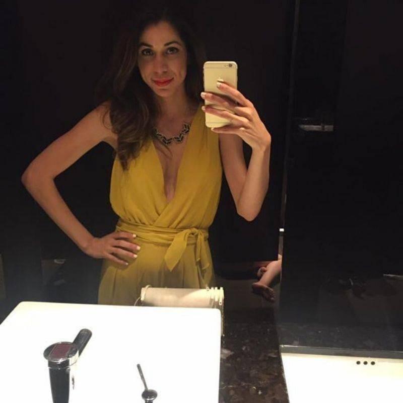 someone taking a selfie in the bathroom with someone puking behind her