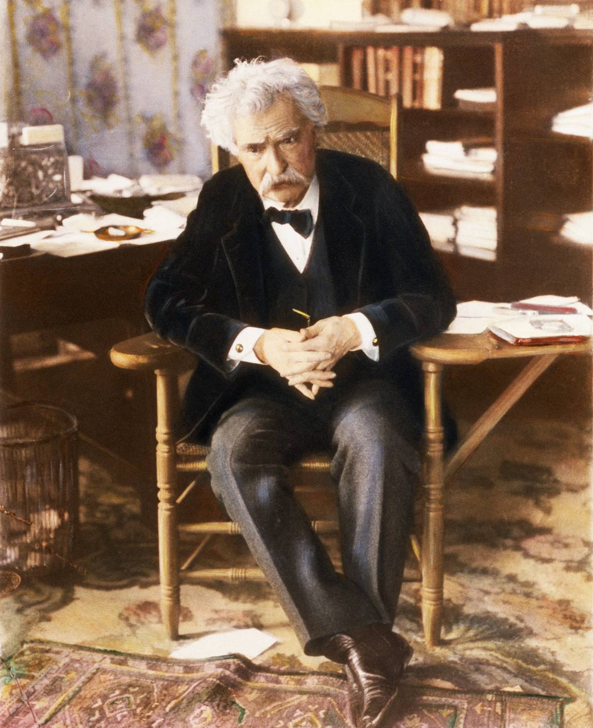 An American author sits in a chair, 1903.