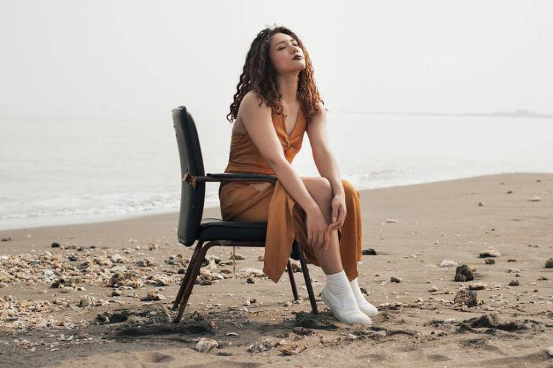 creative a girl sitting on a chair at the beach