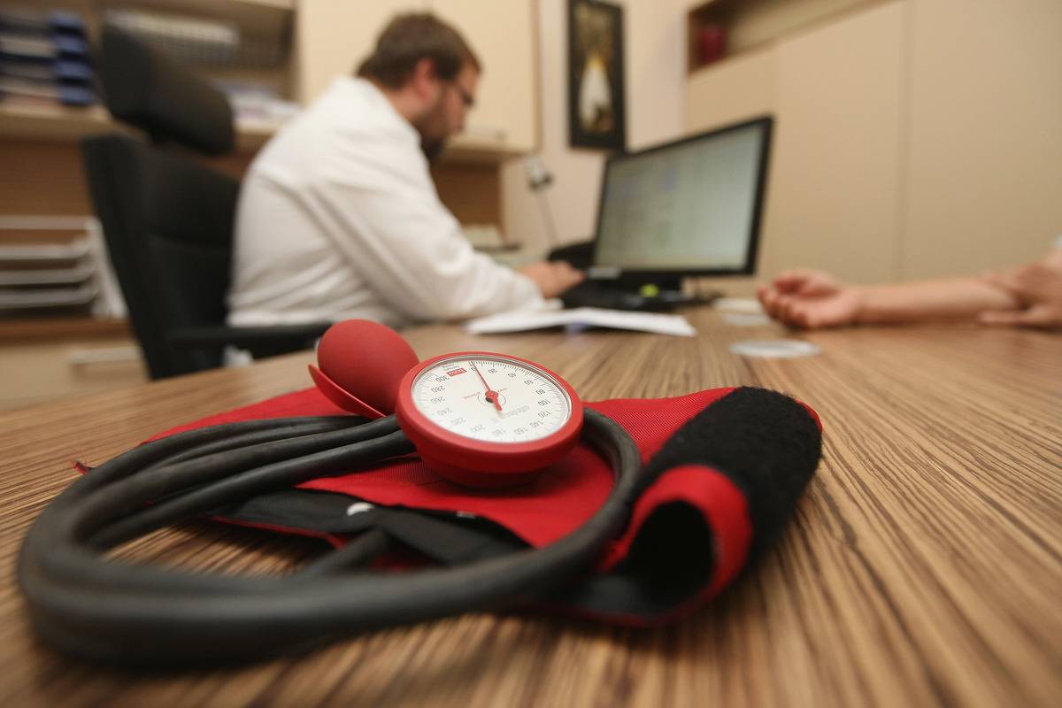 A sphygmomanometer, or blood pressure meter, is seen on a doctor's desk in his office.