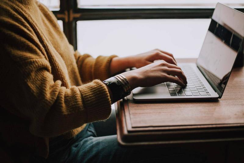 typing a woman typing on a laptop