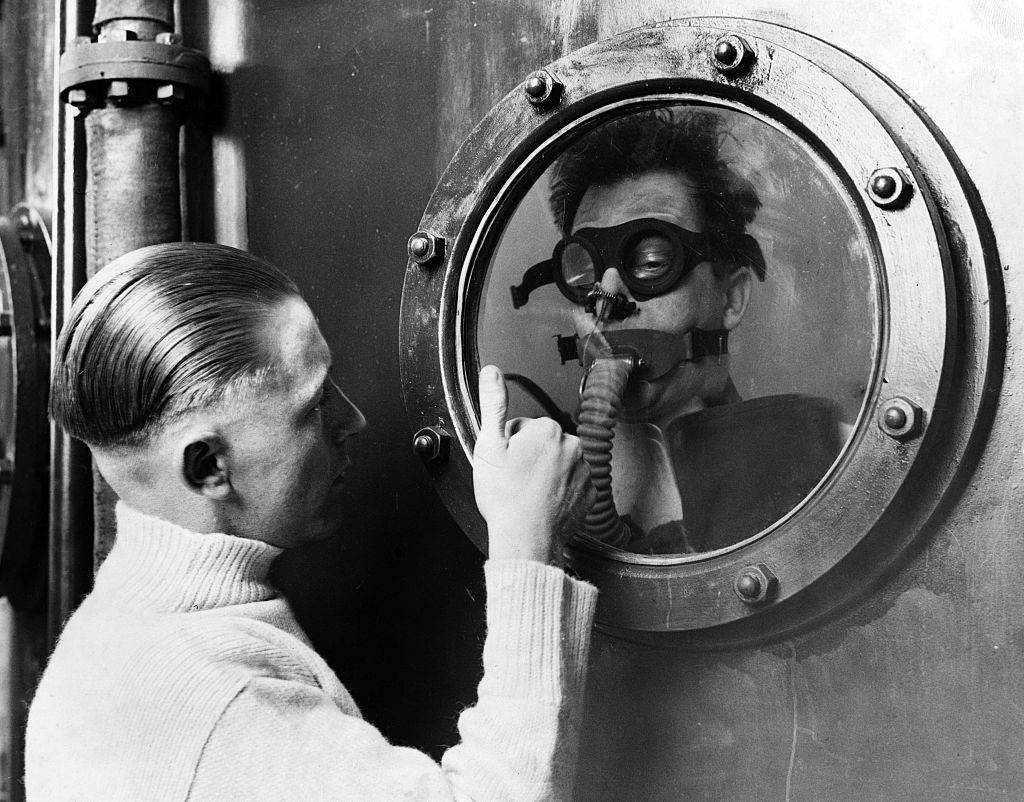 An instructor signalling to a seaman at the bottom of a fifteen foot water tank