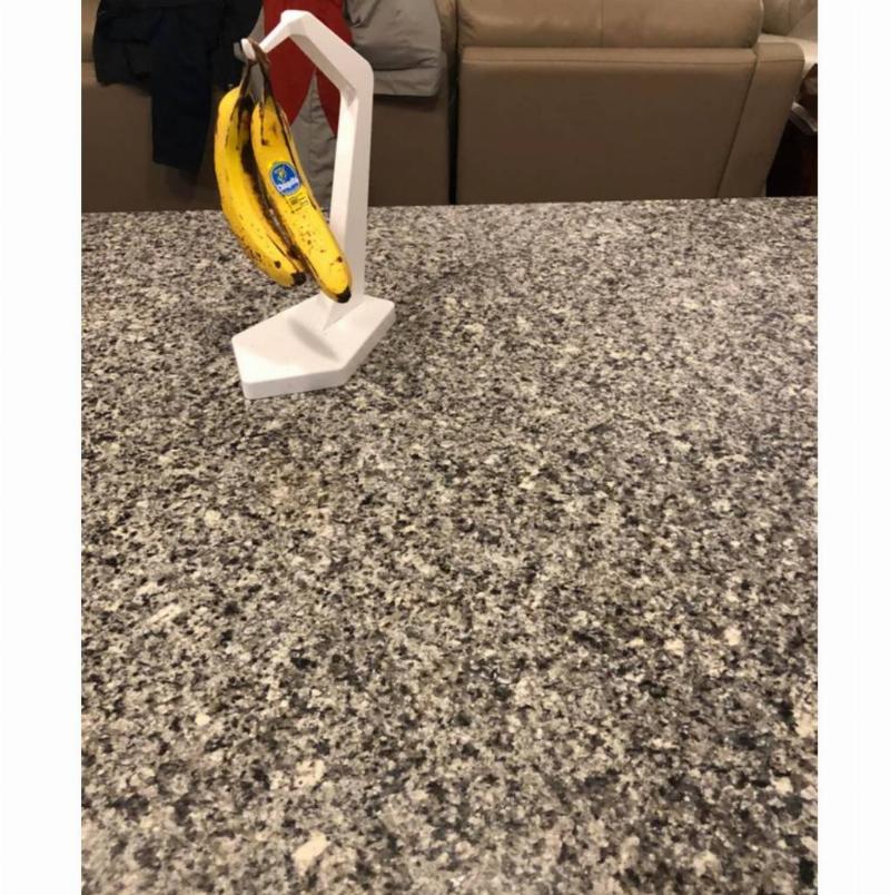 kitchen counter with bananas hanging on a holder