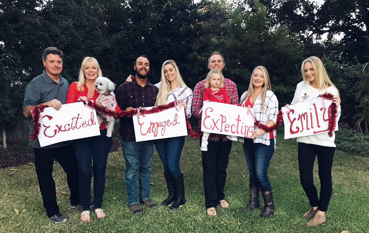 Family poses during photoshoot with signs that say 
