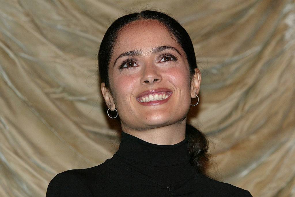 Hayek smiling for a photo in a black turtleneck