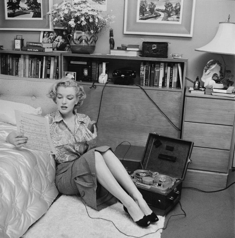 marilyn monroe reading sheet music while sitting on a bedroom floor with a tape player on the side