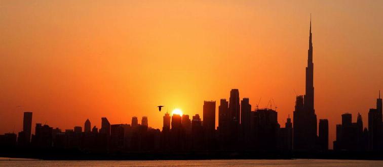A picture taken on February 14, 2022 shows a general view of the skyline of downtown Dubai with Burj Khalifa at sunset, in the Gulf emirate of Dubai