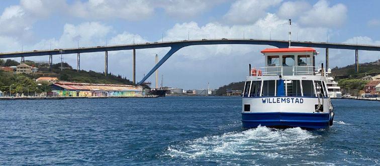 A boat moves across Sint Anna Bay towards the Queen Juliana bridge, in Willemstad, Curacao, in the Dutch Caribbean, on March 5, 2020. - The Queen Juliana Bridge is 500m long and 56m height.