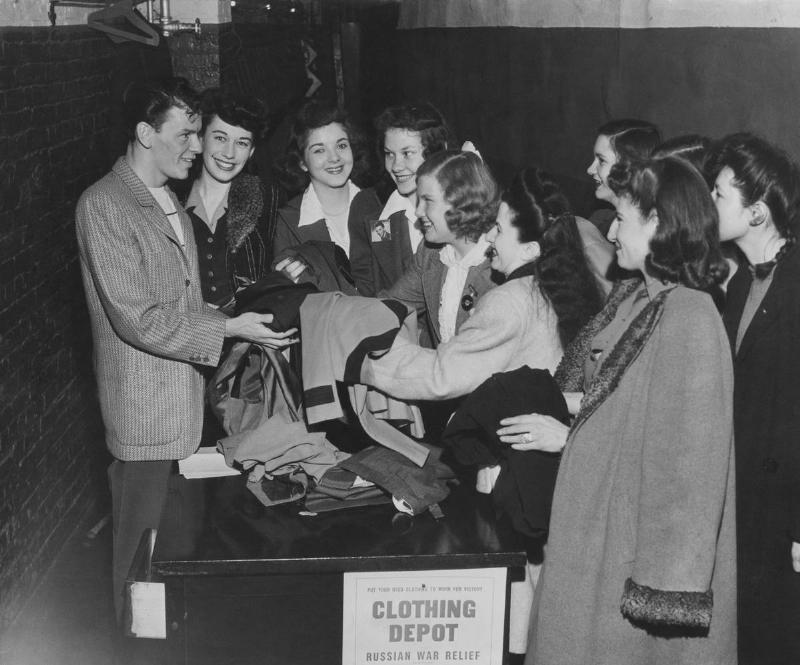 American actor and singer Frank Sinatra (1915 - 1998, left) accepting donations at a Russian War Relief clothing depot in New York, circa 1944