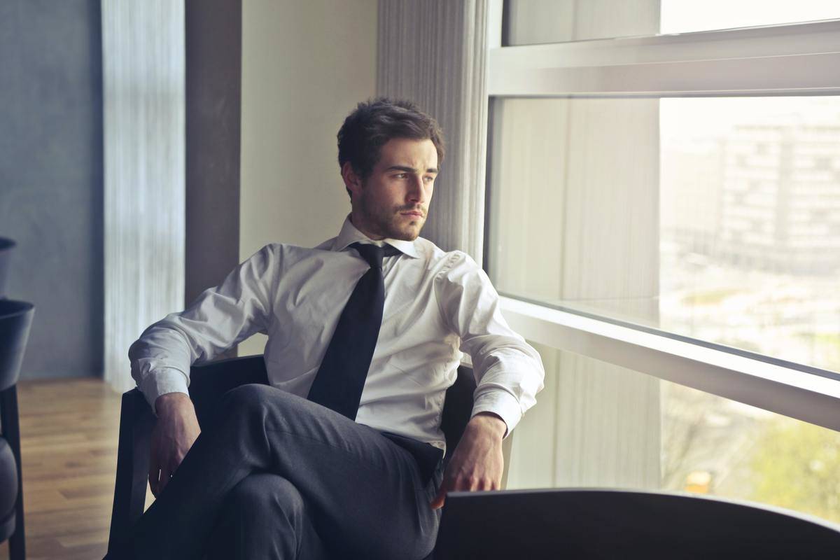 Man sitting on chair in highrise office building