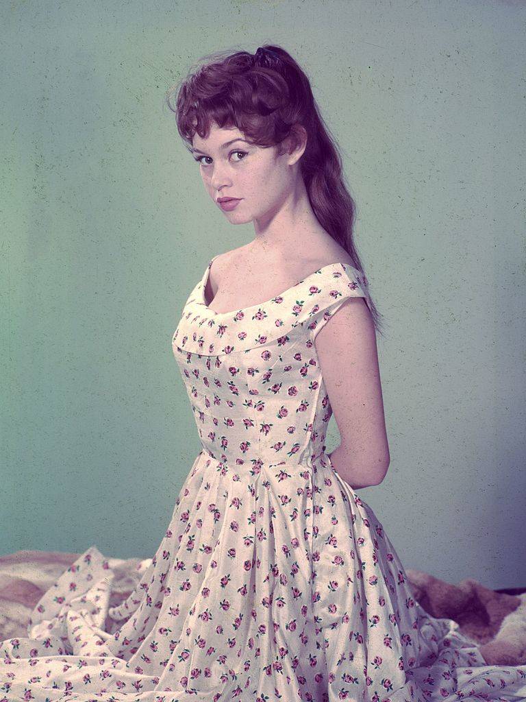 French actress Brigitte Bardot wearing a white floral dress in 1955