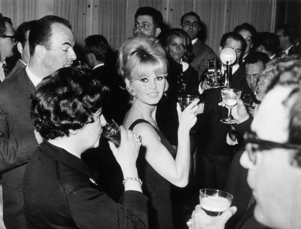 French film star Brigitte Bardot raises her glass at a press conference