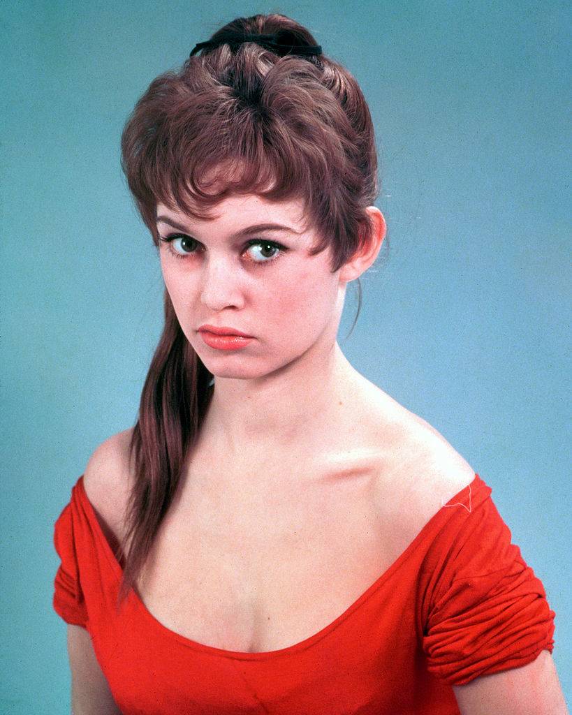 French actress Brigitte Bardot wearing a low-necked red dress, circa 1955