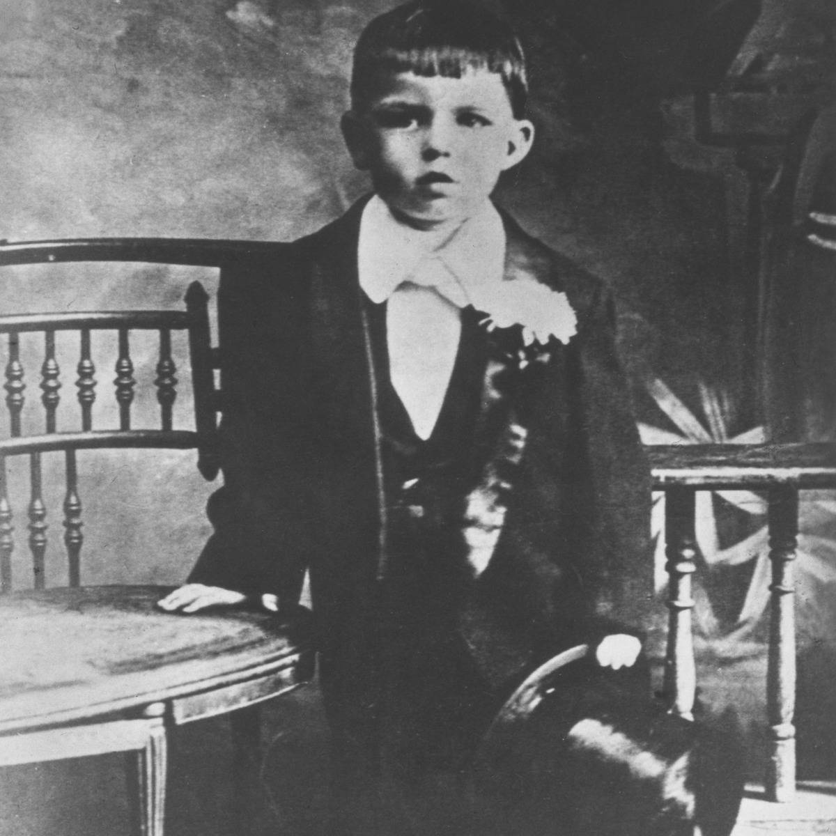 a young frank sinatra poses in a tux and top hat in his hand