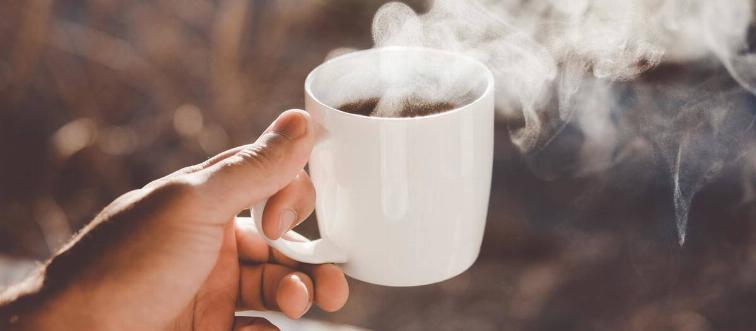 Hand holding a hot cup of coffee